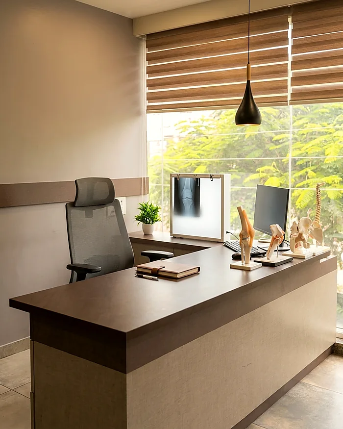 The consulting room at Vishwas Orthopaedic Hospital, Bharuch, with an X-ray view box and anatomical joint models