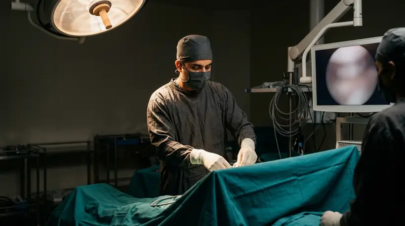 Orthopaedic team performing knee arthroscopy with the camera view on the monitor